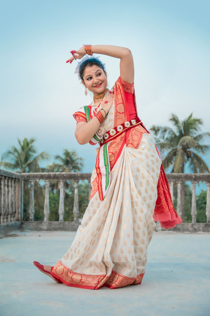 woman in red and white sari standing on gray concrete floor during daytime
